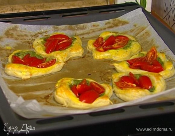 В центр каждой фигурки из теста выложить понемногу соуса песто и несколько долек помидора, сбрызнуть оливковым маслом и отправить противень в разогретую духовку.