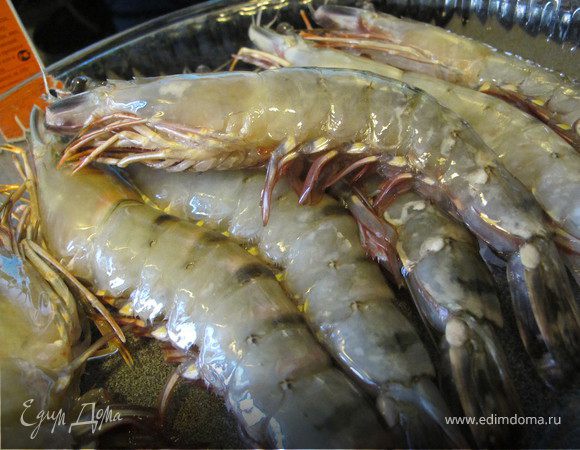 Креветки промыть, отрезать усики, обсушить и сложить в стеклянную форму. 