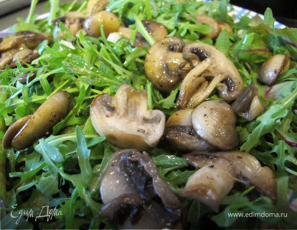 Выложить на большую тарелку листья салата и грибы.