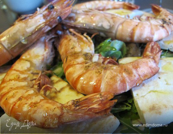 Выложить на листья салата креветки, по кругу питу, полить заправкой и присыпать семечками тыквы.