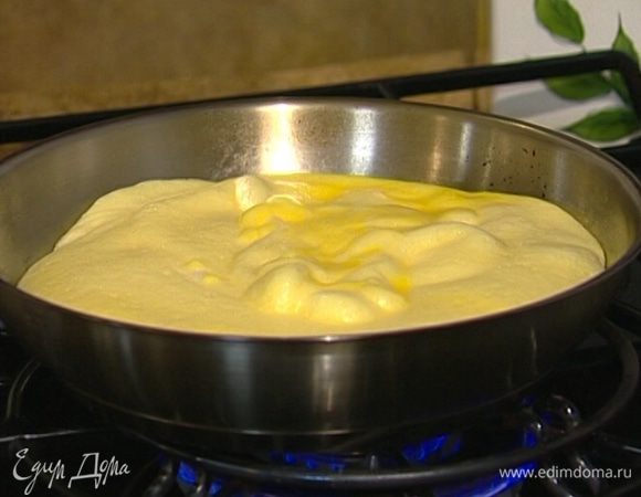 Разогреть сковороду, которую можно ставить в духовку, смазать ее оливковым маслом и выложить яичную массу. 
