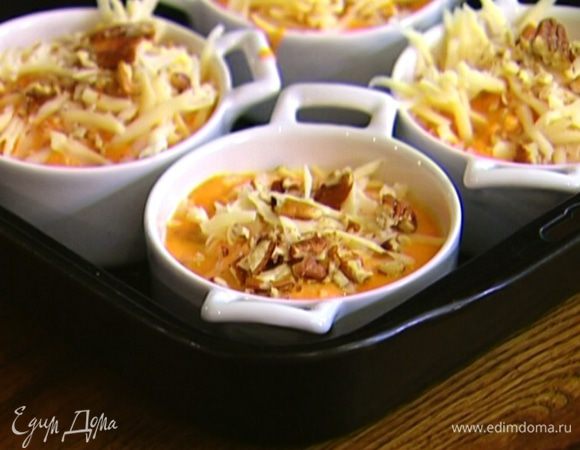 Разложить тыквенную массу в небольшие керамические формочки, присыпать сыром и оставшимися орехами.