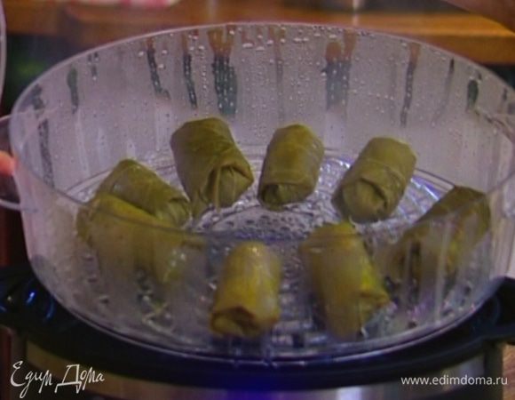 Разложить понемногу рисовой начинки на виноградные листья, свернуть конвертиками, выложить в пароварку и томить на пару минут десять.