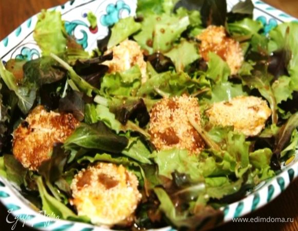 Салатный микс выложить в глубокую салатницу, полить половиной заправки, сверху выложить кусочки козьего сыра и полить оставшейся заправкой.