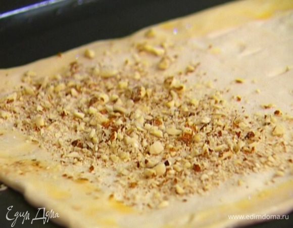 Смазать противень растительным маслом, уложить в него тесто. Яйцо взбить и промазать им края теста. Целую половину теста посыпать измельченным миндалем.