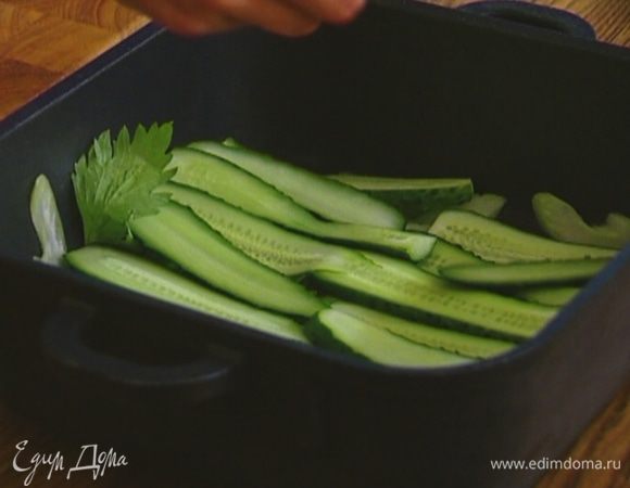 В тяжелую жаропрочную форму выложить кусочки сельдерея, затем полоски огурца.