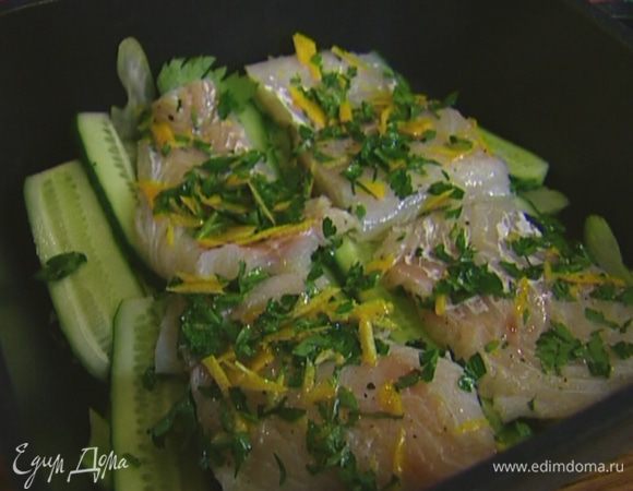 Рыбу нарезать порционными кусками, обвалять в смеси цедры с петрушкой, выложить в форму на огурцы, сбрызнуть оставшимся лимонным соком и оливковым маслом.