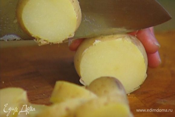 Картофель отварить в мундире, а затем, не очищая, нарезать крупными ломтиками.