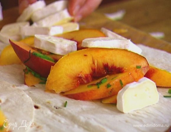 На одну половину каждого лаваша выложить персики с луком и кусочки сыра, а другой половиной накрыть.