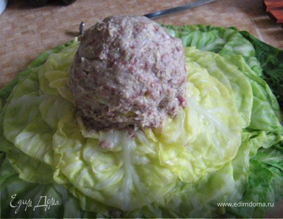 По максимуму развернем приваренные листья и начнем фаршировать. Подготовьте мисочку или чашку с водой, чтоб смачивать ладони когда фарш начнет прилипать к ним, а не к капустным листьям. Итак. Берем жменьку фарша и наносим ее на капустку. Нанесли, завернули листики, сформировали шар.