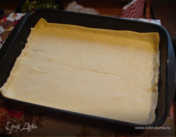 Противень смазать оливковым маслом. Раскатать 1 пласт теста, уложить на противень с бортиками.