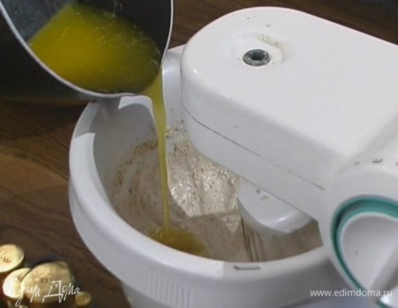 Влить растопленное масло, добавить 100 г сахарной пудры и муку, все перемешать.