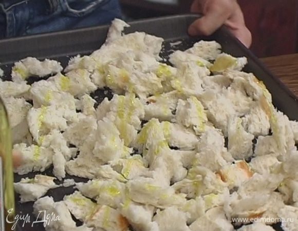 Хлеб поломать на небольшие кусочки, уложить на противень, слегка сбрызнуть оливковым маслом и запекать крутоны в разогретой духовке 8−10 минут.