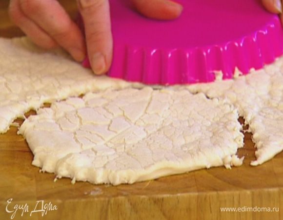 Взять две небольшие формочки для выпечки, вырезать ими из теста круги.