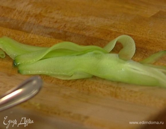 Огурец очистить от кожуры овощечисткой, затем ею же нарезать очень тонкие, почти прозрачные полоски. 