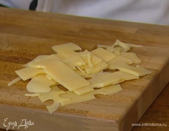 Сыр нарезать тонкими пластинками и вместе с беконом выложить на салат.