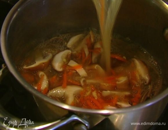 Прогретый бульон с грибами влить в кастрюлю с лапшой, добавить соевый соус и морскую капусту, все перемешать. 