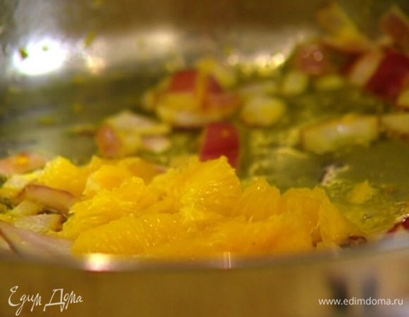 Прямо над сковородой острым ножом вырезать из очищенного апельсина мякоть без перепонок и добавить ее к луку с цедрой. 