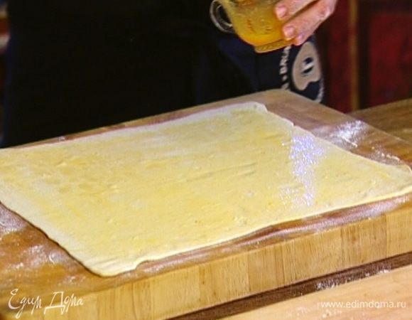 Слоеное тесто раскатать и промазать всю поверхность желтком.