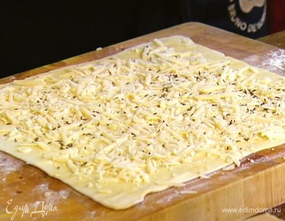 Сыр натереть на крупной терке и равномерно выложить на тесто. Сверху посыпать тмином.