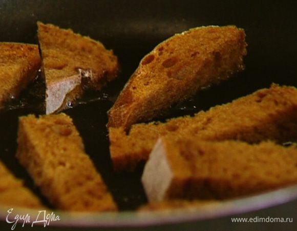 Разогреть в сковороде оливковое масло и обжаривать хлебные палочки со всех сторон до получения золотистой корочки, а затем выложить на бумажное полотенце, чтобы убрать излишки жира. Пока палочки не остыли, натереть их чесноком. 