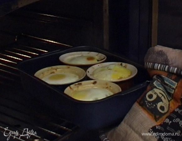 Поставить в глубокий противень формочки с яйцами и налить в него кипяток по верхний край формочек. Запекать в разогретой духовке 10-12 минут.