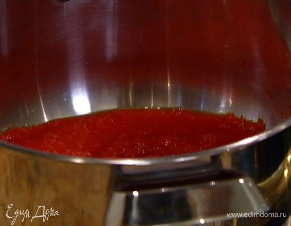 В большой кастрюле разогреть оливковое масло, обжарить нарезанный лук и 2 зубчика чеснока, добавить помидоры. Потушить 3—4 минуты и влить 3 половника бульона.