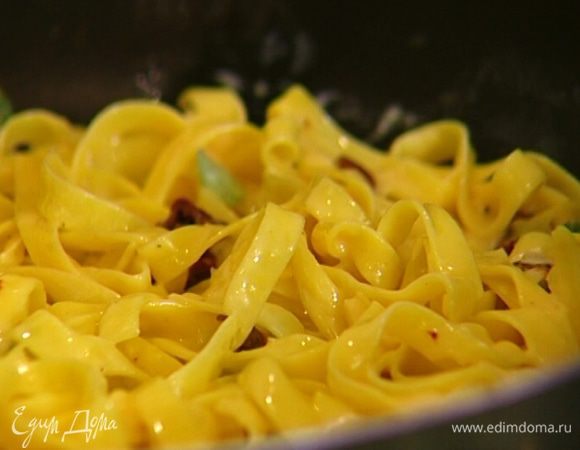 Разогреть в сковороде оливковое и сливочное масло, выложить макароны, разровнять их и прогревать на среднем огне. 
