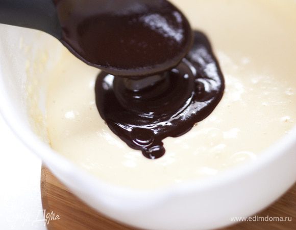 Соединить получившуюся шоколадную массу со взбитыми яйцами и мукой, добавить орехи и осторожно перемешать.