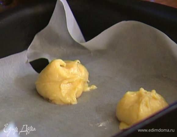 Противень выстелить бумагой для выпечки, смазать ее оливковым маслом.
Выложить на противень тесто при помощи столовой ложки, каждый раз предварительно опуская ее в стакан с холодной водой, чтобы тесто не прилипало. 
