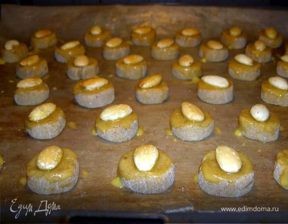 Скатаем колбаску диаметром 2,5-3см, нарежем кружками толлщиной 1,5см. Разложим на застеленный противень и смажем желтками немного разведенными водой. По центру каждого положим орешек. Выпекаем 15 минут в духовке, разогретой до 180С.