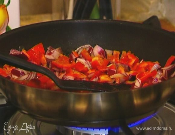 Приготовить начинку: разогреть в сковороде 1 ст. ложку оливкового масла и тушить лук, сладкий перец и чеснок 5–7 минут на небольшом огне.