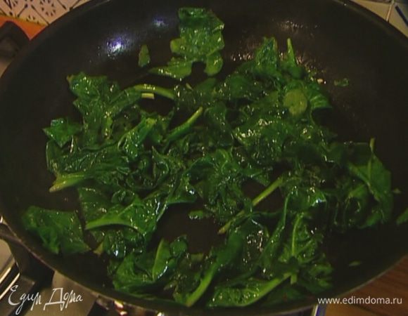 Разогреть в сковороде 1 ст. ложку оливкового масла, выложить шпинат, добавить оставшийся лимонный сок и, помешивая, тушить 2–3 минуты.