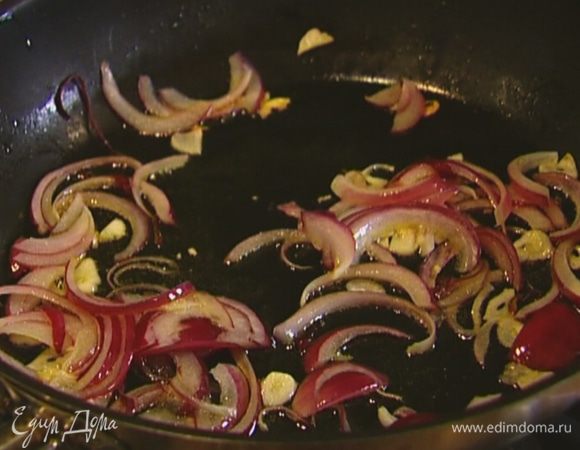 Разогреть в тяжелой сковороде оливковое масло и, периодически помешивая, томить лук и чеснок на медленном огне.
