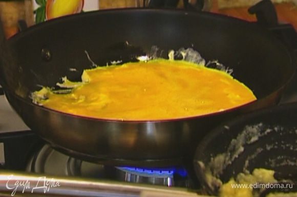Разогреть в сковороде оливковое масло, влить яичную массу и жарить, слегка приподнимая края.
