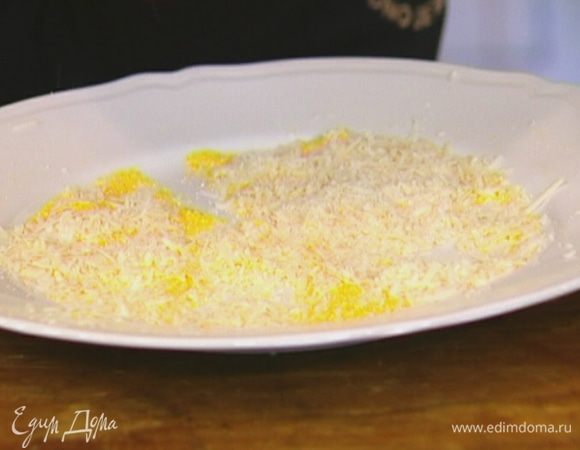Кукурузную крупу насыпать в плоскую тарелку, добавить натертый сыр, перемешать.