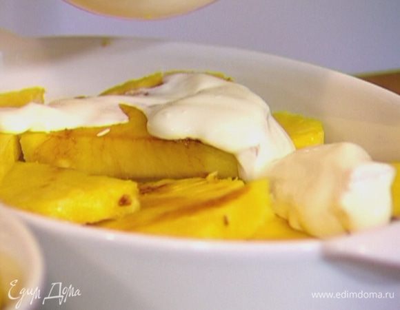 На ананасы выложить сметану, равномерно ее распределить, посыпать сахаром и запекать под грилем 5–7 минут.