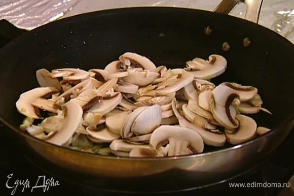 Грибы порезать дольками и добавить в сковороду к луку с чесноком, посыпать прованскими травами, посолить и поперчить. Обжаривать минут 5–7, до готовности грибов.