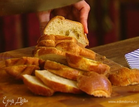 Булочки нарезать ломтиками и выложить плотным слоем в форму, смазанную оливковым маслом.