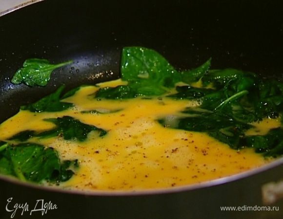 Разбить в сковороду со шпинатом яйца, все перемешать и снять с огня.