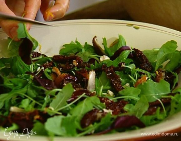 Руколу выложить в глубокую тарелку, добавить финики и помидоры.