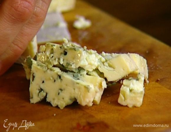 Нарезать небольшими кубиками 50 г голубого сыра и выложить на салат.