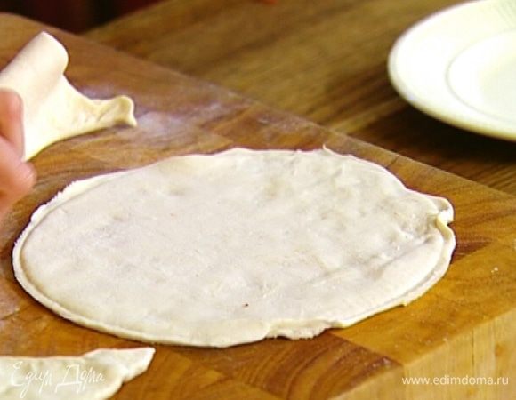 Тесто раскатать на доске, присыпанной мукой, вырезать из него две круглые лепешки.