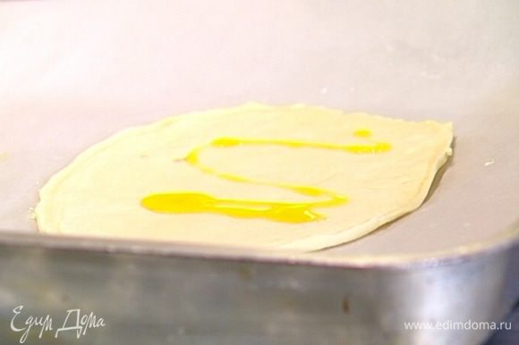 Противень застелить бумагой для выпечки, смазать ее растительным маслом. На бумагу выложить лепешки, сбрызнуть их оливковым маслом и равномерно распределить по поверхности каждой из них 2–3 ст. ложки томатного соуса.