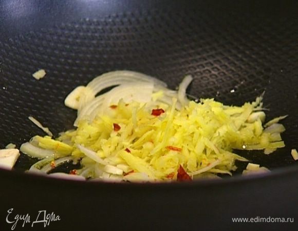 Разогреть в сковороде вок оливковое масло, выложить имбирь, лук, чеснок и раскрошенный перец чили. Все перемешать и обжаривать 2–3 минуты.