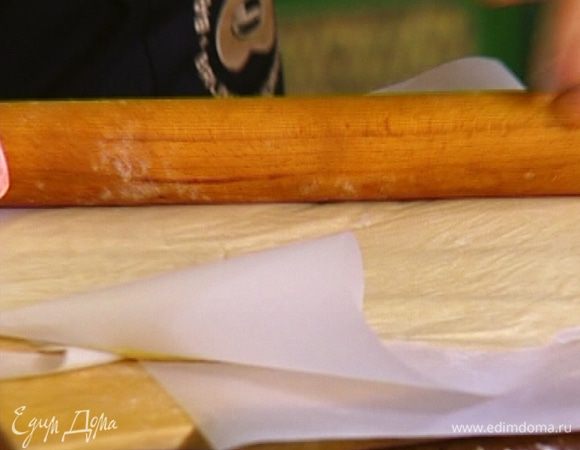 Тесто вынуть из холодильника, поместить между двух листов бумаги для выпечки и раскатать скалкой в пласт, а затем прямо в бумаге опять отправить в холодильник. 