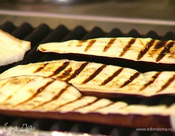 Баклажан нарезать вдоль на ломтики толщиной полсантиметра и обжарить под грилем с двух сторон.