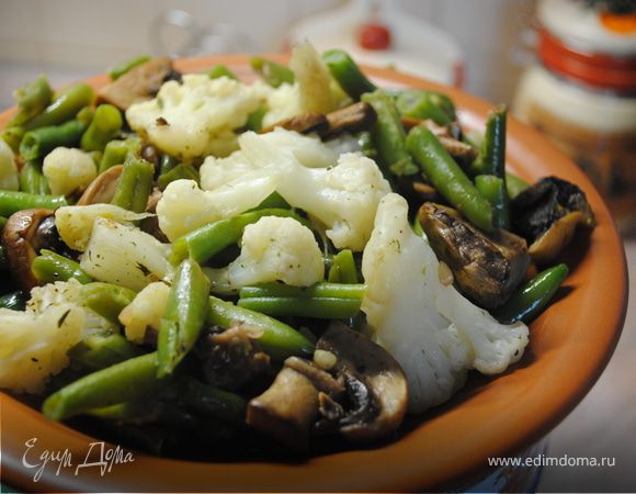 Нарезать шампиньоны, слегка обжарить их на оливковом масле. Добавить фасоль и капусту, посолить, добавить специи. Закрыть крышкой и тушить мин 15.