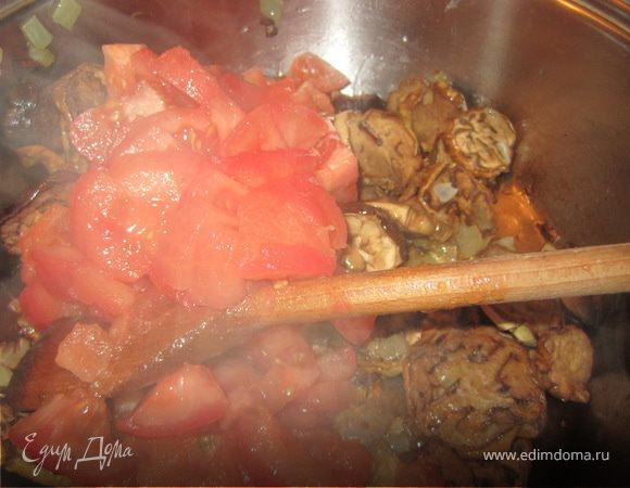 Помидоры надрезать, ошпарить и снять с них кожицу.
Порезать крупнимы кусочками и добавить к баклажанам.