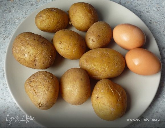 Картофель отварить в мундире. Тем временем также отварить яйца. Картофель остудить, почистить и нарезать пластинками. 